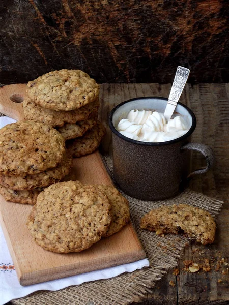 Mehllose glutenfreie Erdnussbutter, Haferflocken, Trockenobst-Kekse und eine Tasse Kakao mit Marshmallows auf Holzuntergrund. vertikal. — Stockfoto