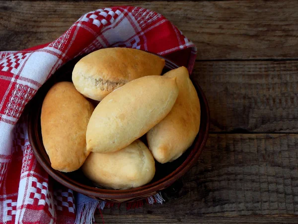 Pasteles con repollo en un plato de barro sobre un fondo de madera — Foto de Stock