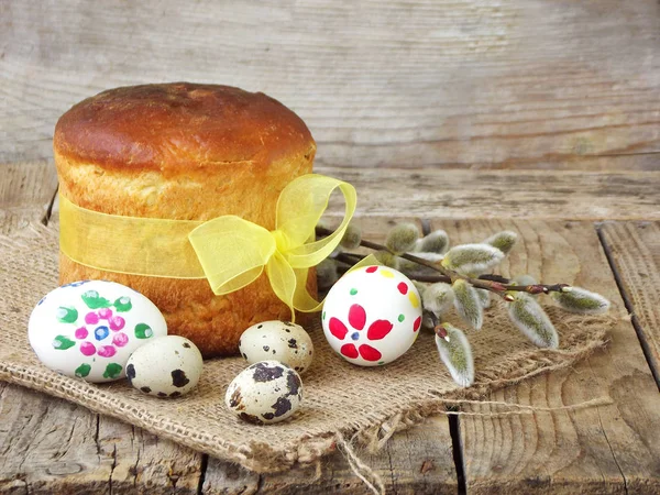 Tatlı ekmeğin, paskanın, söğüt dallarının ve hafif ahşap arka planda yumurtaların Paskalya kompozisyonu. Ortodoks kulich. Metin için alanı olan tatil kahvaltısı kavramı.