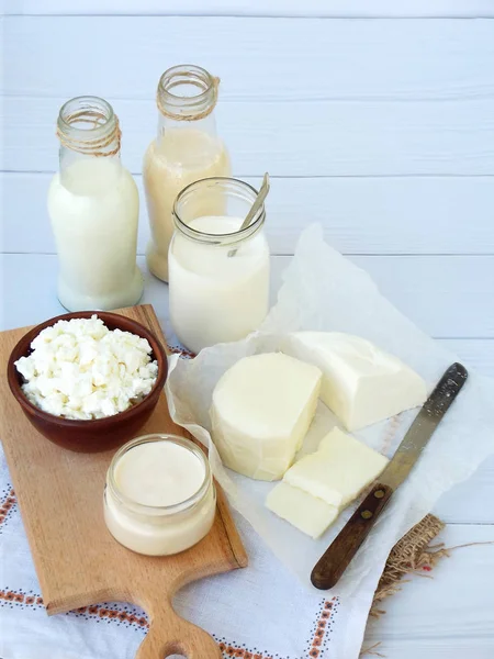 Sada čerstvých mléčných výrobků na dřevěné pozadí: mléko, sýr, cottage, jogurt, vejce, mozzarella, ryazhenka, feta. — Stock fotografie