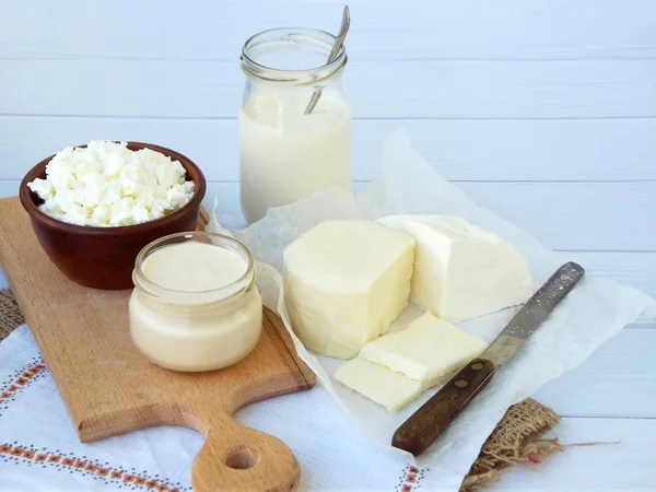 Ahşap arka plan üzerinde taze süt ürünleri kümesi: süt, peynir, yazlık, yoğurt, yumurta, mozzarella peyniri, ryazhenka, beyaz.