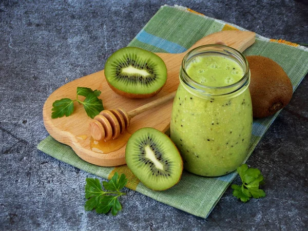 kivi, yulaf ezmesi, fındık ve bal koyu arka plan üzerinde sağlıklı yeşil smoothies.