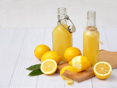 Taze sıkılmış limon suyu şişesi ve limon açık renkli. Vitamin içeceği veya kokteyl için. Seçici odak. Metin için yer