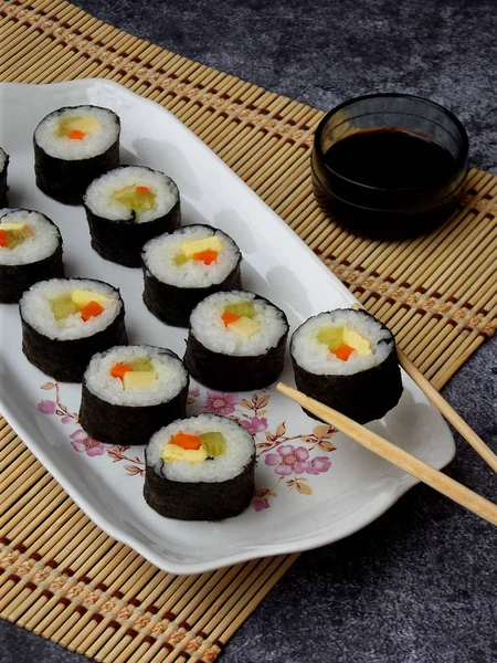 Sushi di piring putih, latar belakang abu-abu. Makanan tradisional Asia. Diet makanan sehat. Fokus selektif. Ruang untuk teks — Stok Foto