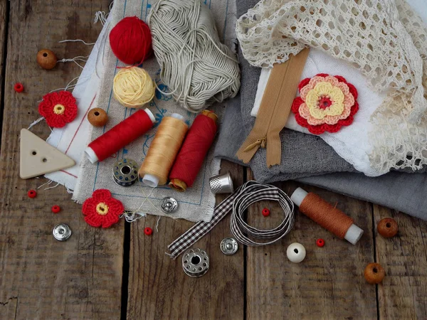 Red and grey accessories for needlework on wooden background. Knitting, embroidery, sewing. Small business. Income from hobby. — Stock Photo, Image