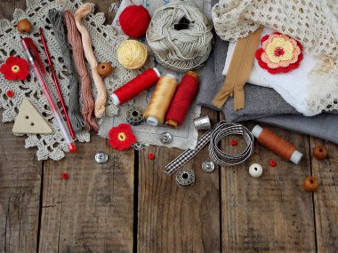 İğne işi ahşap arka plan üzerinde kırmızı ve gri aksesuarları. Örgü, nakış, dikiş. Küçük işletme. Hobi geliri.