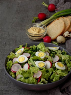 Vitamini Salata marul, turp, yeşil soğan ve yumurta, terbiyeli bitkisel yağ ve plaka gri beton zemin üzerine hardal ile. Sağlıklı gıda. Metin için yer