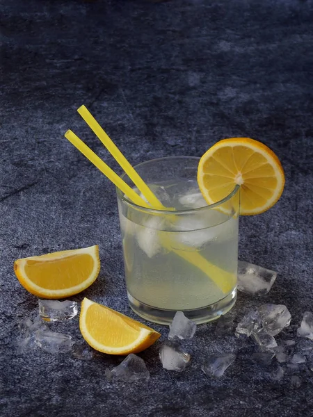 Verres de limonade maison froide avec tranches de citron, glaçons et pailles sur fond sombre. Espace de copie — Photo