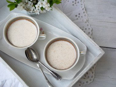 Süt ve peynir mayası gelen Beyaz tatlı basın gösterimine ayıklamak tarçın bardak hafif arka plan ile. Tatlı süzme peynir yapılan jöle benzeri puding. Sağlıklı gıda. Metin için yer