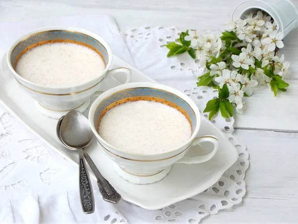 Weißes Dessertjunket aus Milch und Labextrakt mit Zimt in Tassen auf hellem Hintergrund. geleeartiger Pudding aus süßem Quark. gesunde Ernährung. — Stockfoto