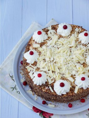 Çikolatalı kek krem ve çilek ahşap arka plan üzerinde rozet ile dekore edilmiş.