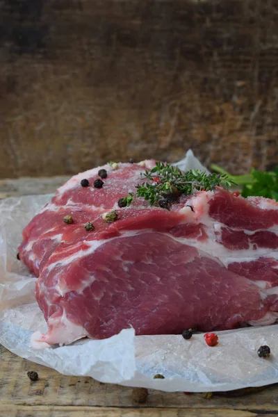 Carne cruda pezzo di carne di maiale e spezie marinata su sfondo di legno. Per bistecche, arrosti, stufati. Spazio per testo — Foto Stock