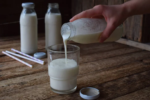 Saure-Milchgetränk oder Joghurt in der Flasche, die aus den Kefir-Körnern und Milch auf hölzernem Hintergrund kommen. Fotografiert mit natürlichem Licht — Stockfoto