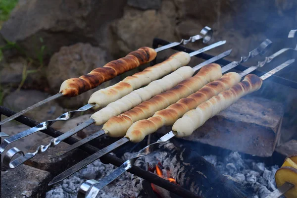 Bâtonnets de pain de pâte cuits sur un feu. Bâtonnets de pain italien à base de farine complète aux herbes — Photo