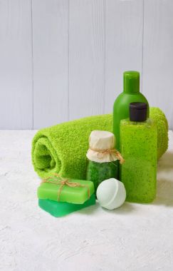 Kireç güzellik threatment ürünleri beyaz beton zemin üzerine yeşil renklerde nane bileşimi: şampuan, sabun, banyo tuzu, havlu, petrol. Çeşitli banyo aksesuarları. Spa için öğeleri.
