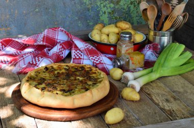 Lezzetli pasta patates, et, peynir, soğan ve biber ile. Pırasa quiche yemek veya ahşap zemin üzerine lanch için. Metniniz için kopya alanı.