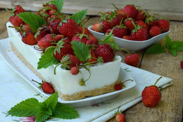 Вкусный чизкейк с ягодами, био домашняя клубника из сада, вкусный и простой торт на деревянном фоне. Пространство для копирования текста — стоковое фото