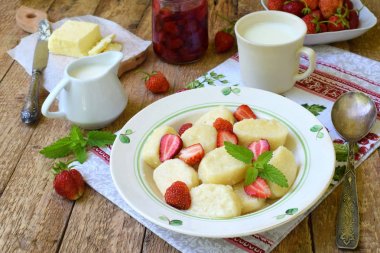 Yaz berry kahvaltı. Tatlı tembel pierogi, ekşi krema, tereyağı ve çilek ahşap arka plan üzerinde köfte. İtalyan gnocchi. Metniniz için kopya alanı.