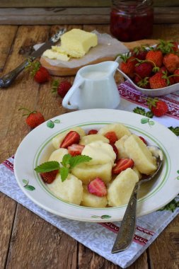 Yaz berry kahvaltı. Tatlı tembel pierogi, ekşi krema, tereyağı ve çilek ahşap arka plan üzerinde köfte. İtalyan gnocchi. Metniniz için kopya alanı.