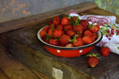 Ahşap arka plan üzerinde kapta bahçesinden organik taze çilek. Metniniz için kopya alanı