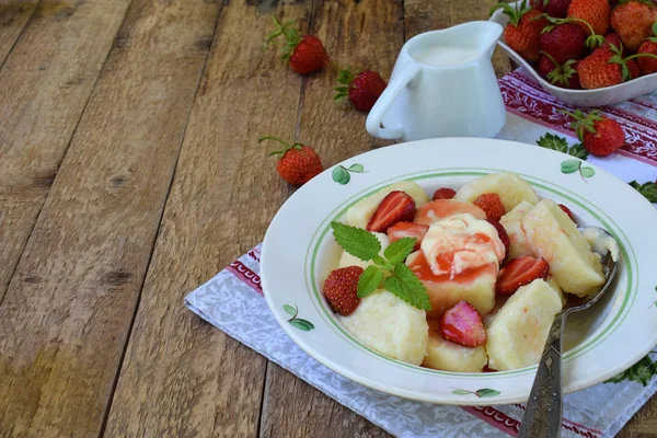 Yaz berry kahvaltı. Tatlı tembel pierogi, ekşi krema, tereyağı ve çilek ahşap arka plan üzerinde köfte. İtalyan gnocchi. Metniniz için kopya alanı.