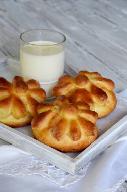 Ayran akşam yemeği buns çiçek formunda ahşap arka plan üzerinde süt ile devam eder. Taze pişmiş tatlı çörek. Homemade pişirme.
