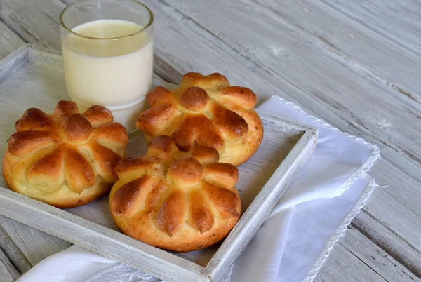 Panecillos de mantequilla en forma de flor servidos con un vaso de leche sobre fondo de madera. Brioche recién horneado. Hornear en casa . — Foto de Stock