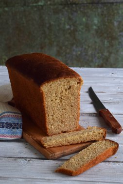 Ahşap arka plan üzerinde beyaz bütün tahıl ekmeği bir somun. Ev yapımı Maya pişirme