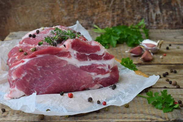 Carne cruda pezzo di carne di maiale e spezie marinata su sfondo di legno. Per bistecche, arrosti, stufati. Spazio per testo — Foto Stock