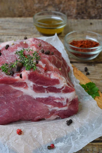 Carne cruda pezzo di carne di maiale e spezie marinata su sfondo di legno. Per bistecche, arrosti, stufati. Spazio per testo — Foto Stock