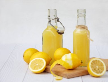 Taze sıkılmış limon suyu şişesi ve limon açık renkli. Vitamin içeceği veya kokteyl için. Seçici odak. Metin için yer.