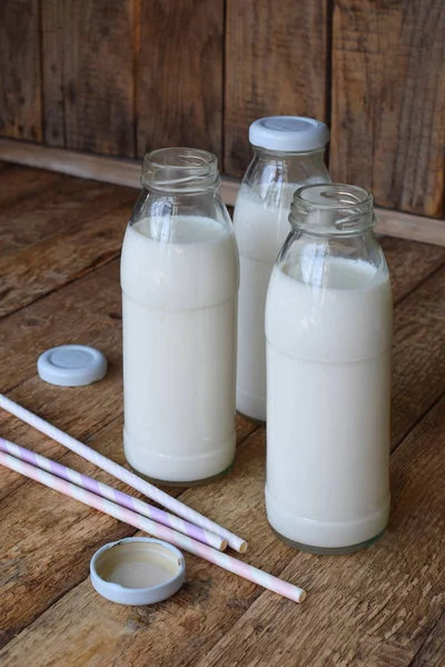 Bebida agria láctea o yogur en botella que proviene de los granos de kéfir y leche sobre fondo de madera. Fotografiado con luz natural —  Fotos de Stock