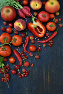 Kırmızı vejetaryen ürün bileşimi: meyve ve sebze ahşap arka plan üzerinde. Elma, domates, kuş üzümü, turp, biber, ahududu, tatlı kiraz. Sağlıklı gıda. Metin için yer kopyalayın