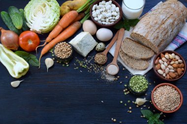 Dengeli beslenme, yemek, diyet, mutfak ve gıda kavramı. Farklı gıda maddeleri - tam tahıllı ekmek, tahıl, sebze, baklagiller, günlük ürünleri, yumurta, fındık, Maya. Sağlıklı beslenme. Üstten Görünüm. Düz yatıyordu.