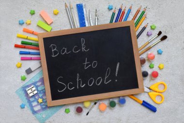 Okul ve aksesuarlar: kalem, işaretçileri, boyalar, kalemler, blackboard hafif bir arka plan üzerinde yazıtlar için. Okula dönüş. Yukarıdan görüntüleyin. Düz yatıyordu