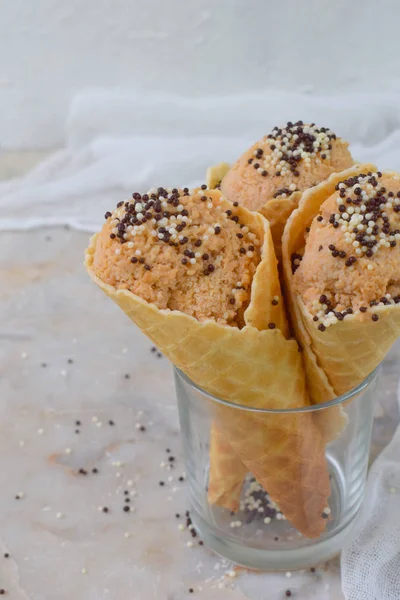 Dietary caramel colored apple ice cream in waffle cone on a light background. Copy space — Stock Photo, Image