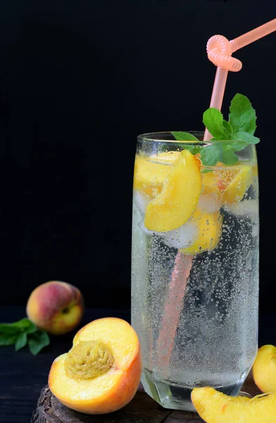 Стакан холодного домашнего персикового лимонада или коктейль мохито с мятой на тёмном фоне. Содовая. Принято. Фотография с естественным освещением — стоковое фото