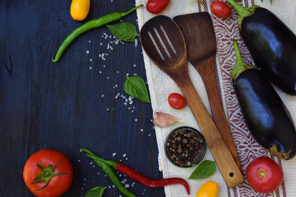 Koncepció bio ökológiai élelmiszer. Az egészséges főzés kellékei. Zöldségek és fűszerek, sötét fából készült háttér. A paradicsom, padlizsán és paprika ételek elkészítése. — Stock Fotó