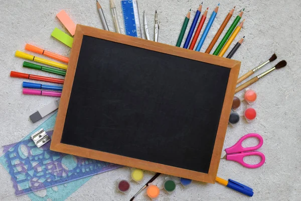 Acessórios de escola e provisões: lápis, marcadores, pinturas, canetas, quadro-negro de inscrições em um contexto leve. De volta à escola. Vista de cima. Depósito plano — Fotografia de Stock