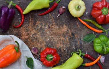 Tatlı ve acı biber ahşap arka plan üzerinde farklı çeşitleri tarifi için bir çerçeve. Gıda sınır. Kopya alanı