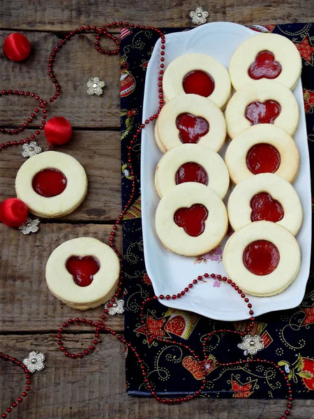 Geleneksel ev yapımı Noel kurabiyeleri - Linzer bisküvi ahşap arka plan üzerinde kırmızı reçel ile dolu. seçici odak.