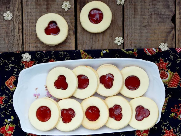 Geleneksel ev yapımı Noel kurabiyeleri - Linzer bisküvi ahşap arka plan üzerinde kırmızı reçel ile dolu. seçici odak.