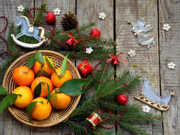 Olgun mandalina, Ladin şube ve ahşap arka plan üzerinde Noel oyuncak sepeti. seçici odak. kopya alanı