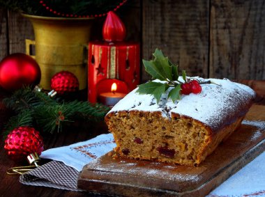 Geleneksel Noel meyveli kek pudra şekeri ve mas süslemeleri, mum ile dekore edilmiştir. kopya alanı. rustik tarzı. seçici odak