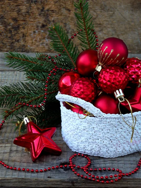 Cesto rotondo all'uncinetto bianco con decorazioni natalizie rosse su sfondo di legno. Anno nuovo e sfondo carta di Natale. Ricevuto. Focus selettivo . — Foto Stock