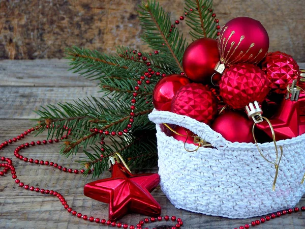 Cesto rotondo all'uncinetto bianco con decorazioni natalizie rosse su sfondo di legno. Anno nuovo e sfondo carta di Natale. Ricevuto. Focus selettivo . — Foto Stock