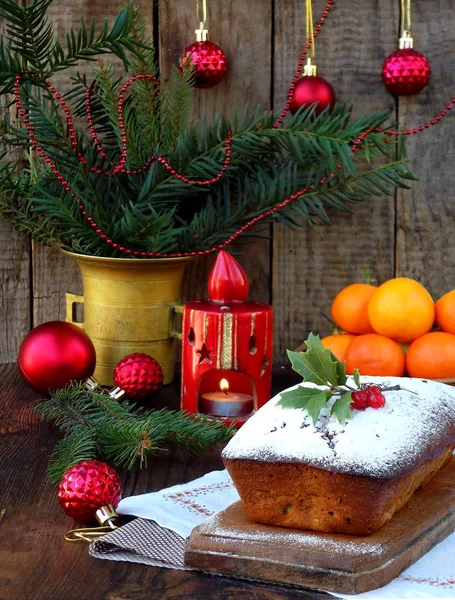 Traditional Christmas fruit cake decorated with powdered sugar and mas decorations, candle. copy space. style rustic. selective focus — Stock Photo, Image