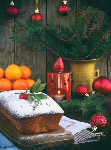 Gâteau traditionnel aux fruits de Noël décoré de sucre en poudre et décorations de Noël, bougie. espace de copie. style rustique. focus sélectif — Photo
