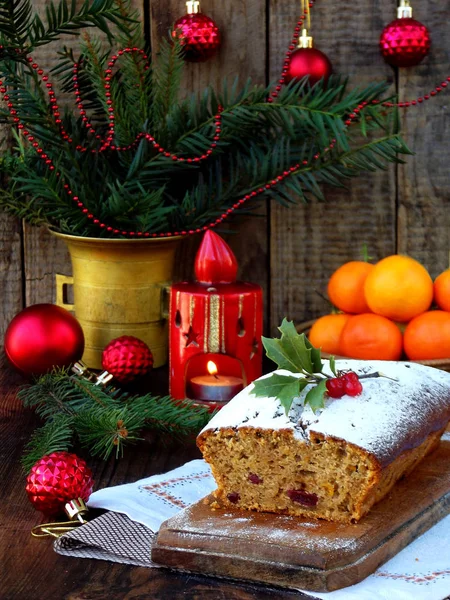 Traditioneller weihnachtlicher Obstkuchen mit Puderzucker und Weihnachtsdekoration, Kerze. Kopierraum. Stil rustikal. Selektiver Fokus — Stockfoto