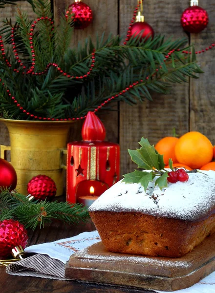 Traditional Christmas fruit cake decorated with powdered sugar and mas decorations, candle. copy space. style rustic. selective focus — Stock Photo, Image